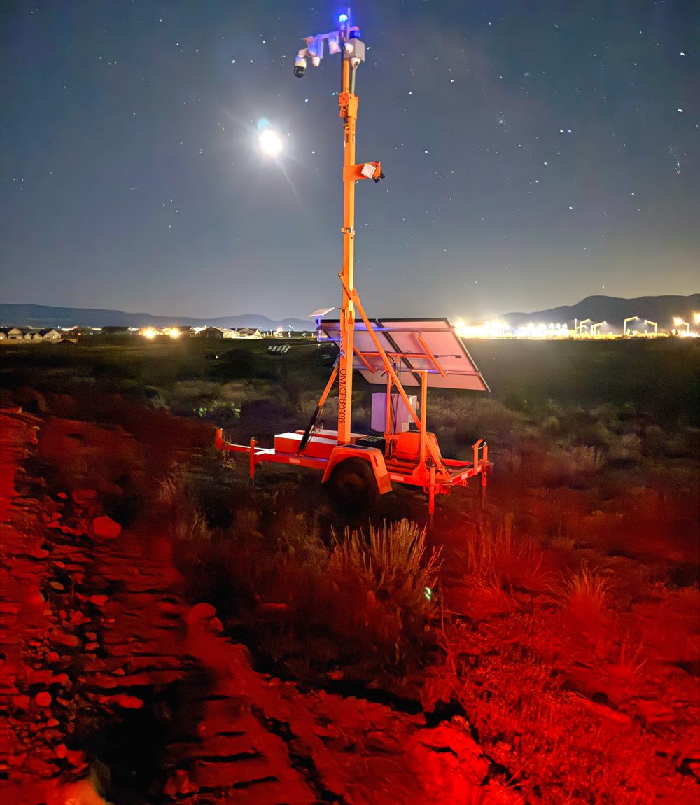 A Guardian Rover 360 trailer standing on Arizona desert ground at night, mast raised under a clear star field.